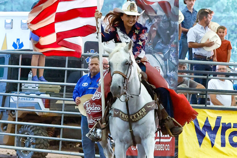 Alfa Agent Emery Norred showcases her pride as Miss Rodeo Alabama as she presents the American flag at a rodeo.