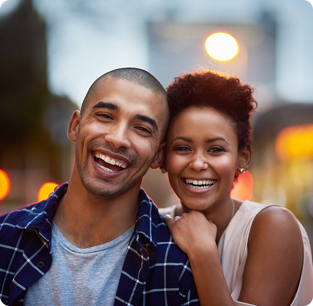 A young couple posing in a city location.
