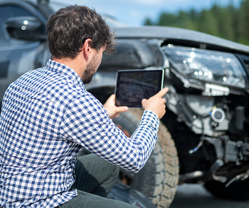 Man taking picture of car damage