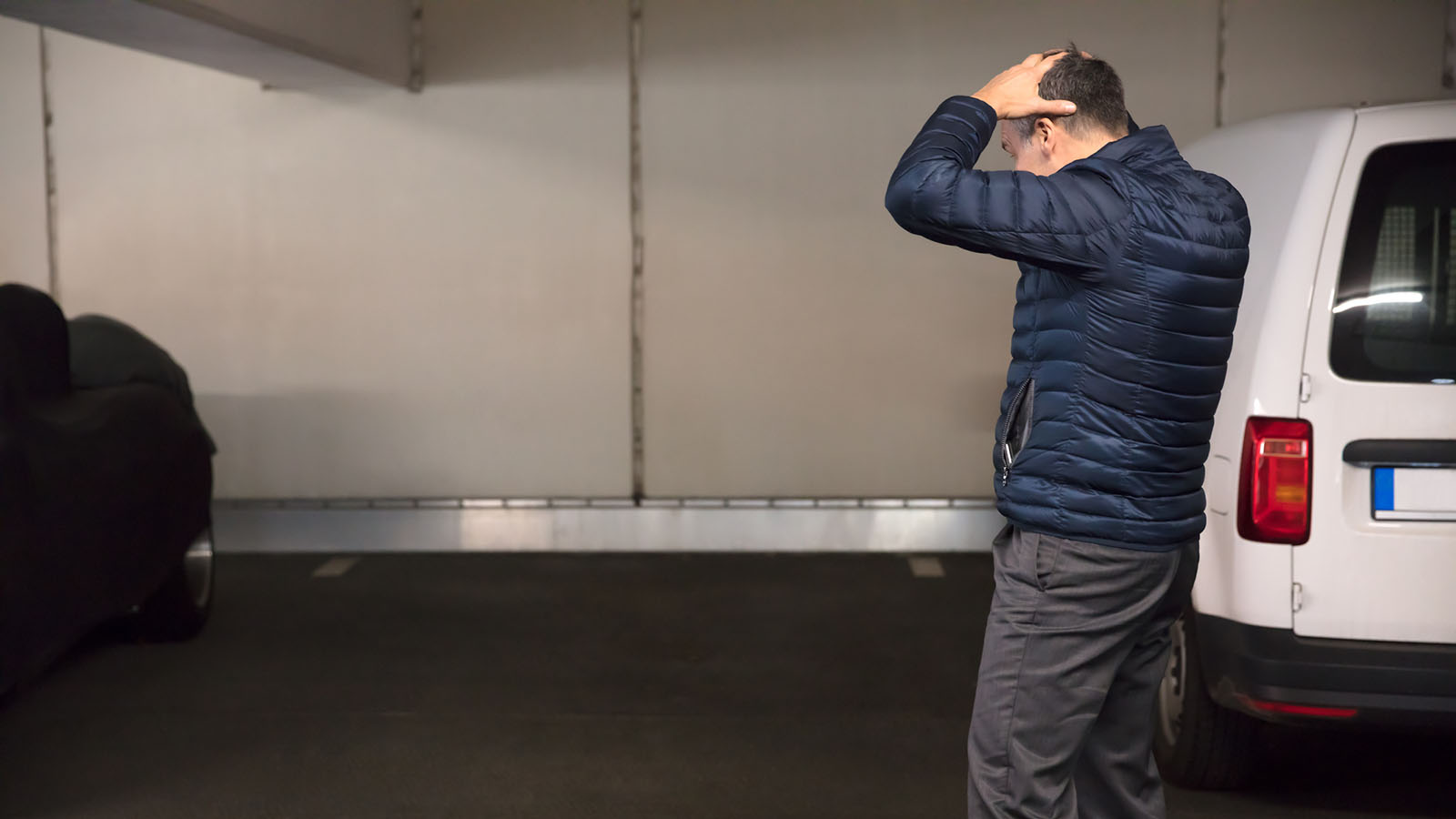 A picture of a man standing with his hands on his head.