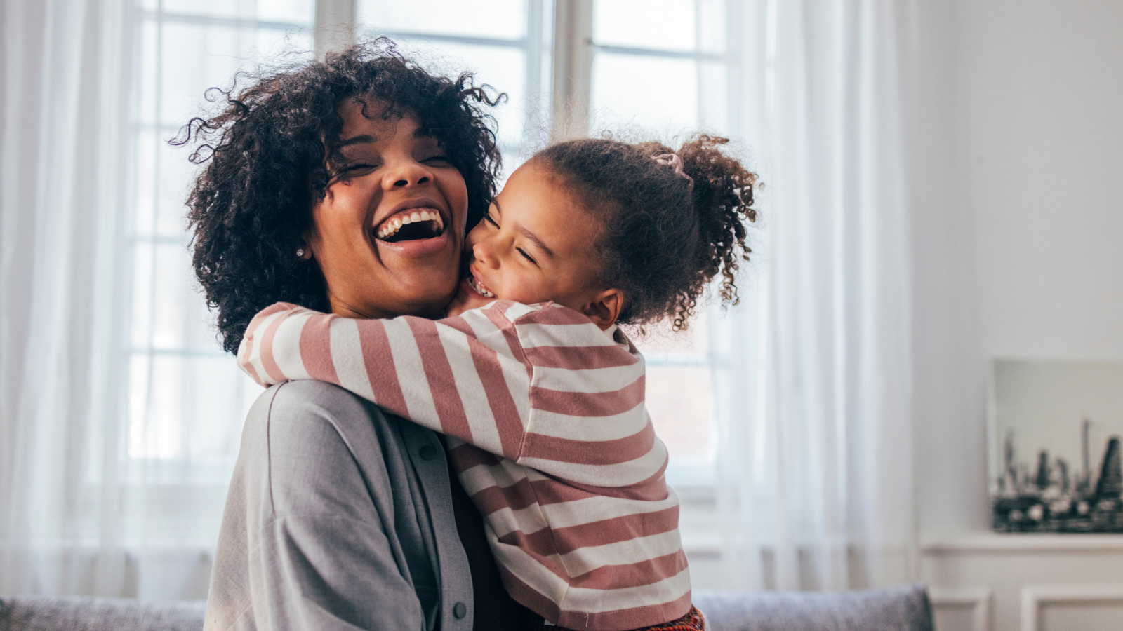 Mom and daughter laughing and hugging.