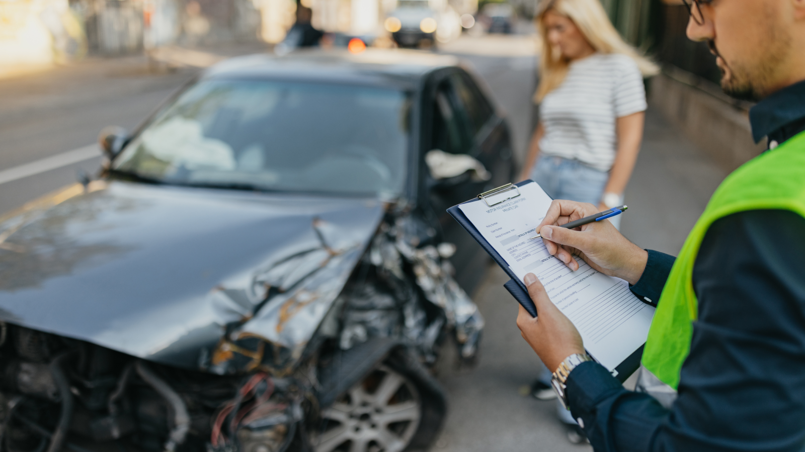 Woman and insurance adjuster assessing vehicle damages after an accident.