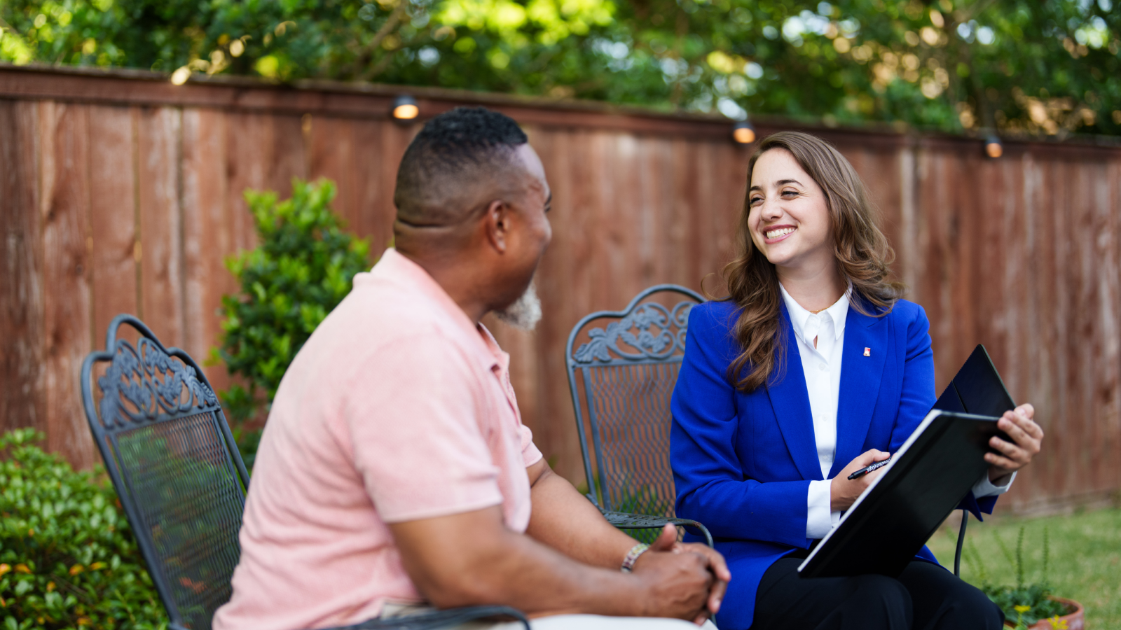 A friendly insurance agent meets with a customer at his home to review coverage.
