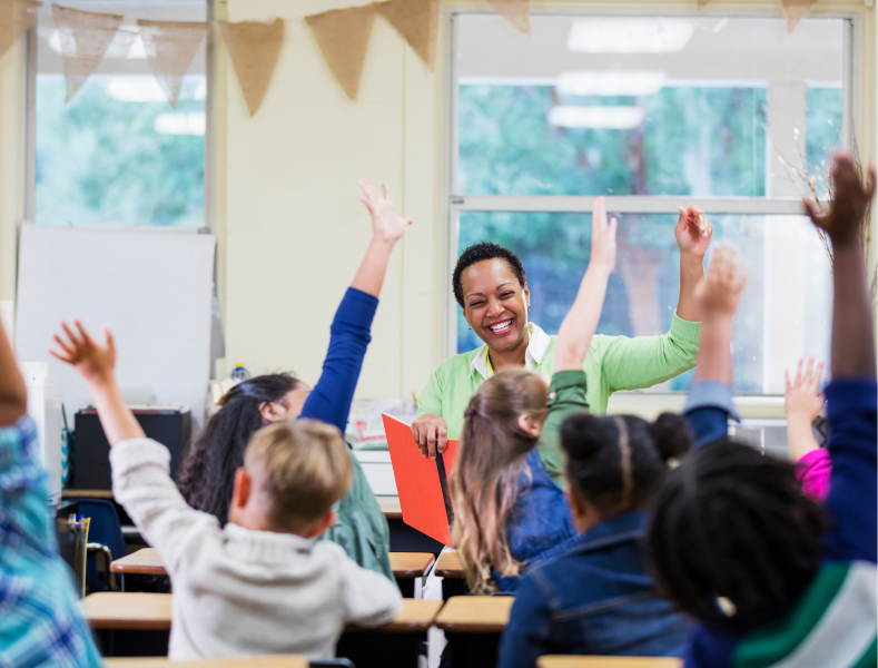 Elementary students raising their hand for the teacher.