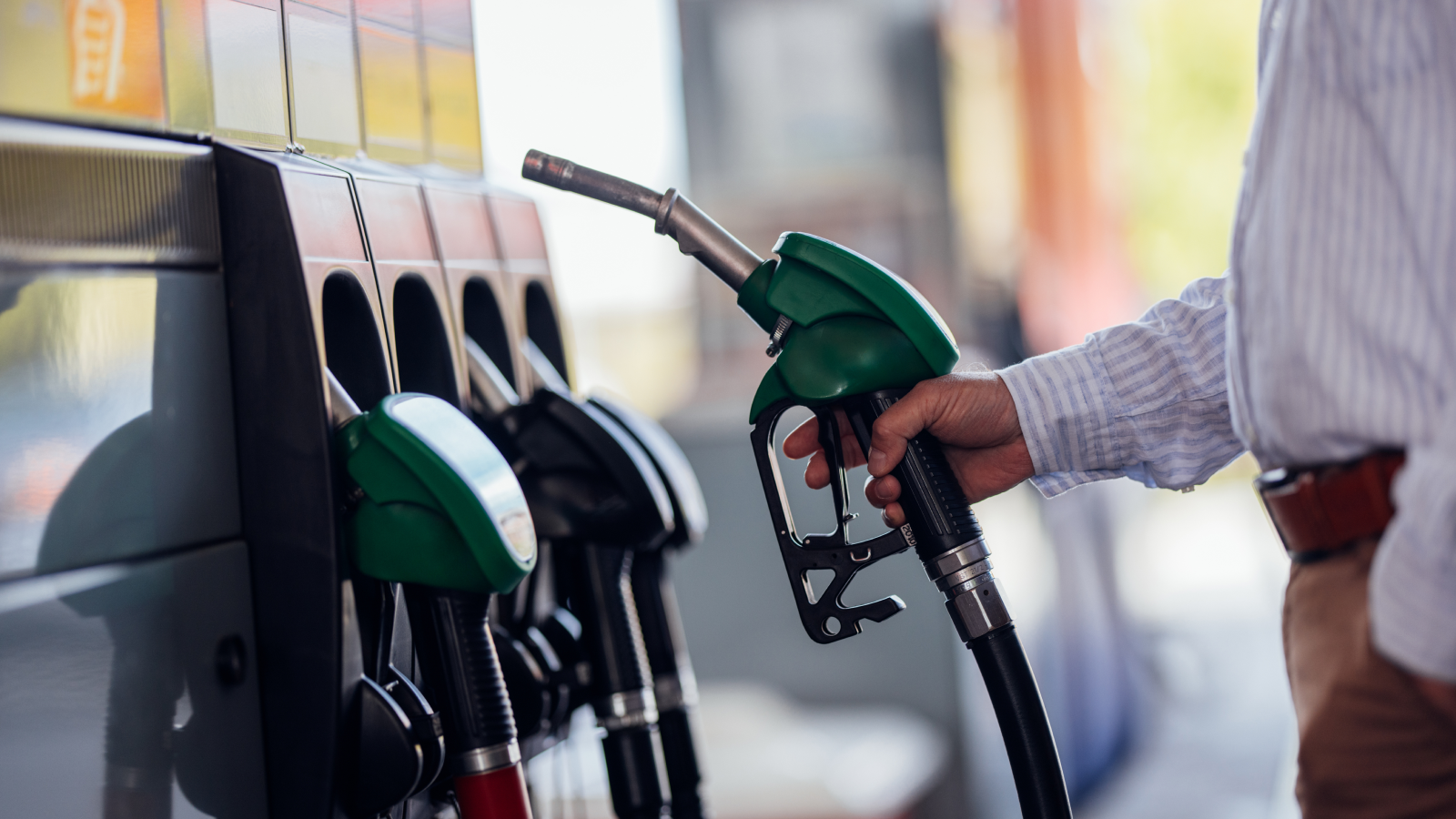 Close up of individual holding gas pump at gas station. 