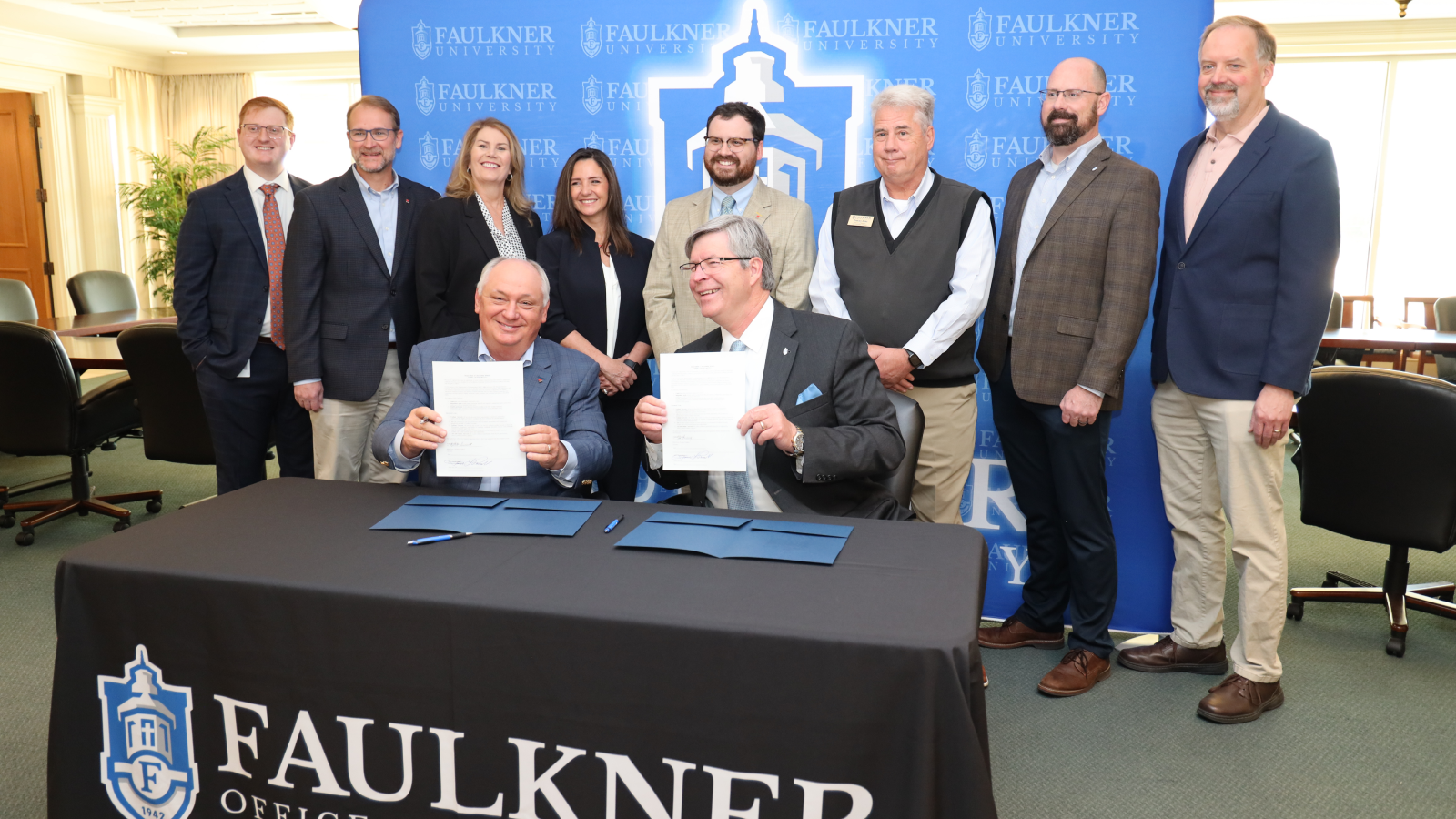 Representatives from Alfa Insurance and Faulkner University smile for photos after signing a memorandum.