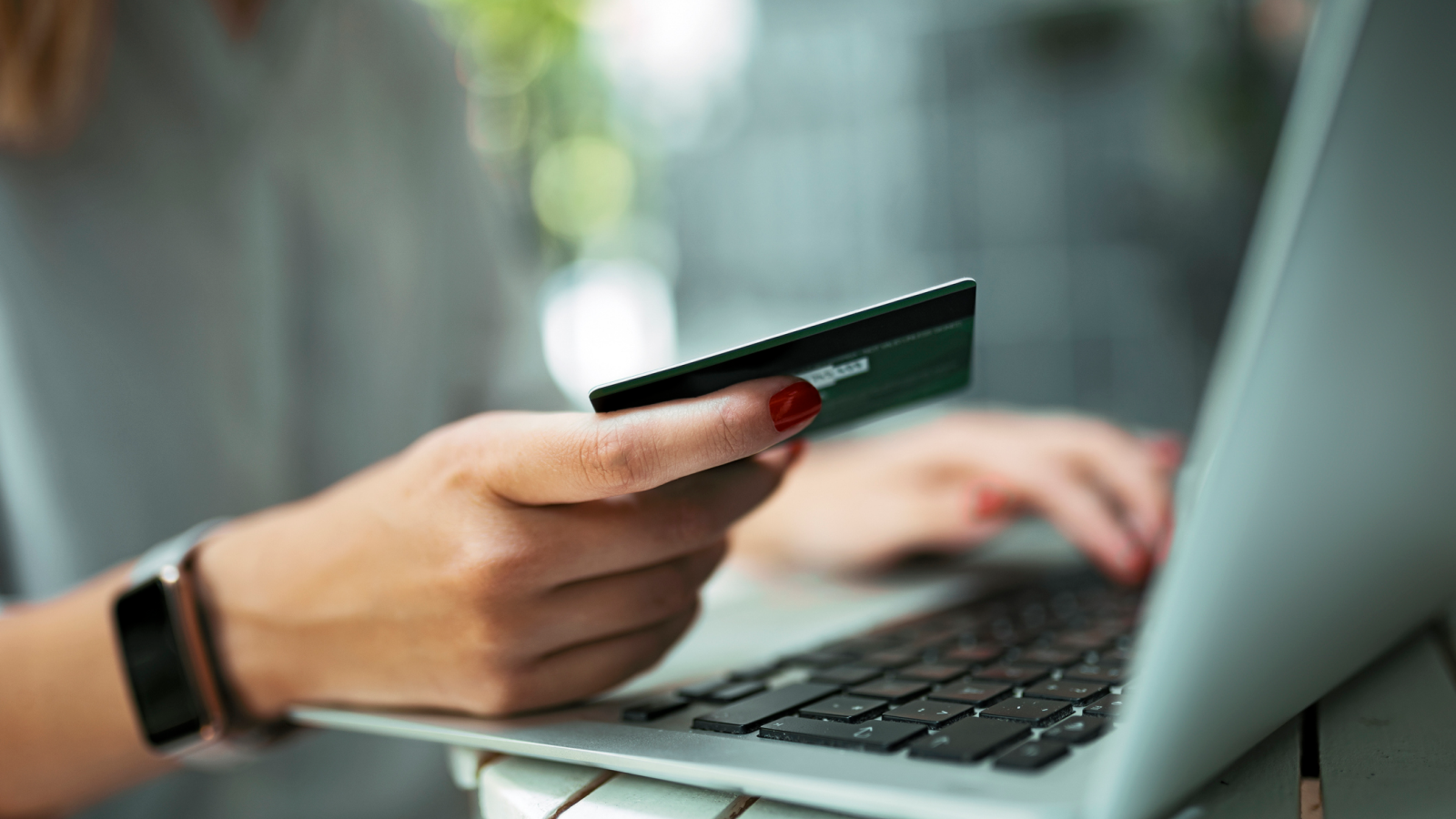 A woman using her laptop and holding a credit card.