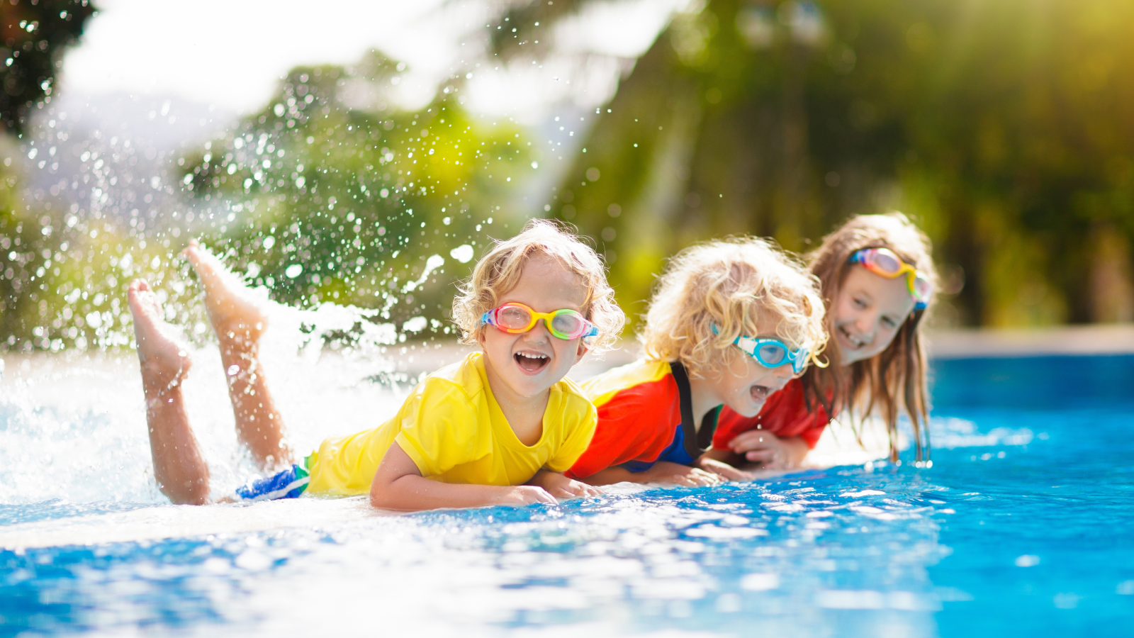 Laughing children sitting on edge of pool.