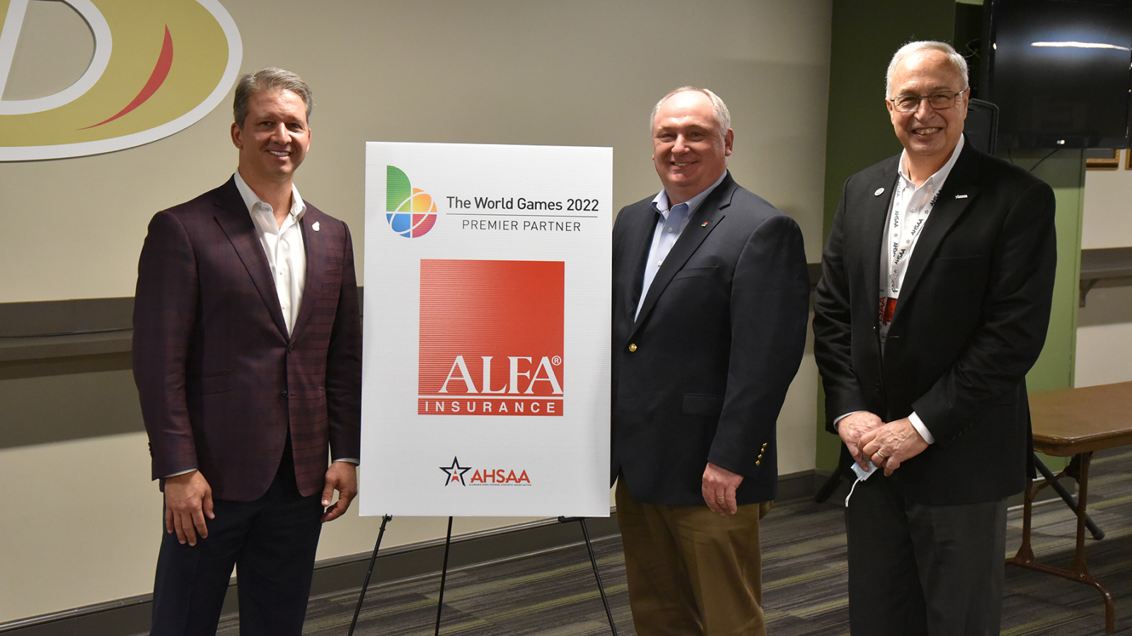 Image of Alfa Insurance President Jimmy Parnell standing with World Game CEO Nick Sellers and Alabama High School Athletic Association Executive Director Steve Savarese.