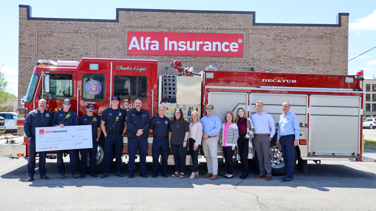 Alfa Insurance members pictured with city of Decatur first responders holding donation check from Alfa Insurance.
