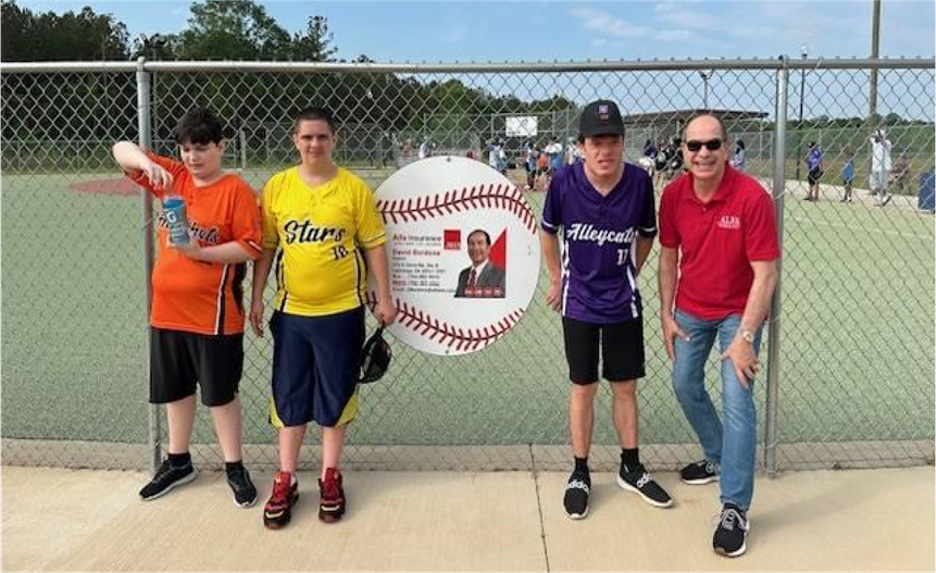 David Bordona, Alfa Insurance agent, standing in front of baseball field with Miracle League participants.