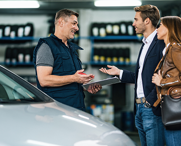 Auto shop worker talking with customers.