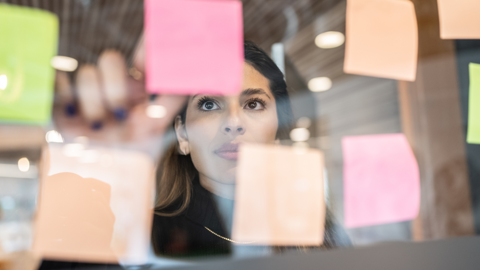 Woman sorting post-it notes.