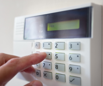 Hand pressing buttons on security system.