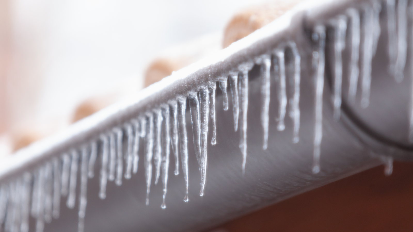 Frozen water drops dripping off a gutter.