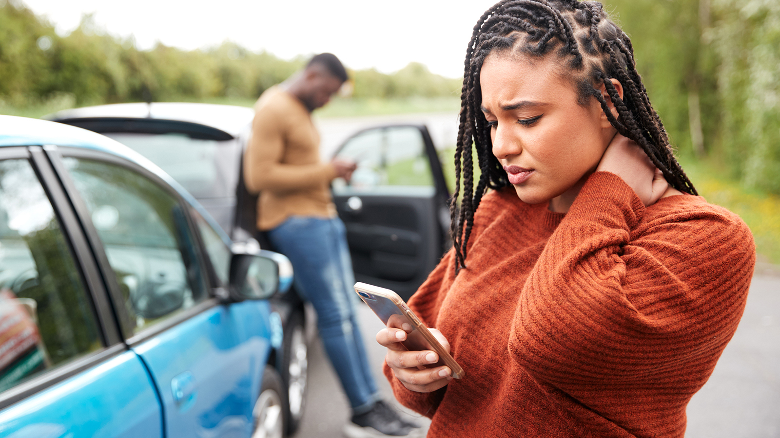 A picture of a woman standing outside looking at her phone.
