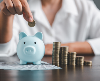 Woman putting coins in a piggy bank.