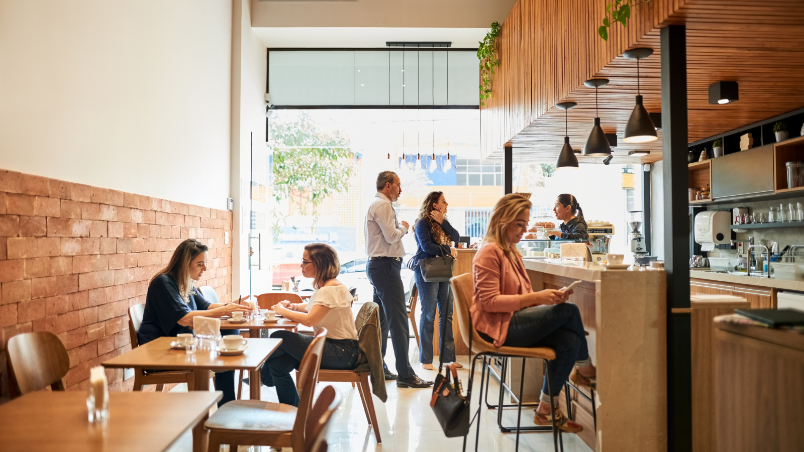 Busy place of business with customers in line and at tables.