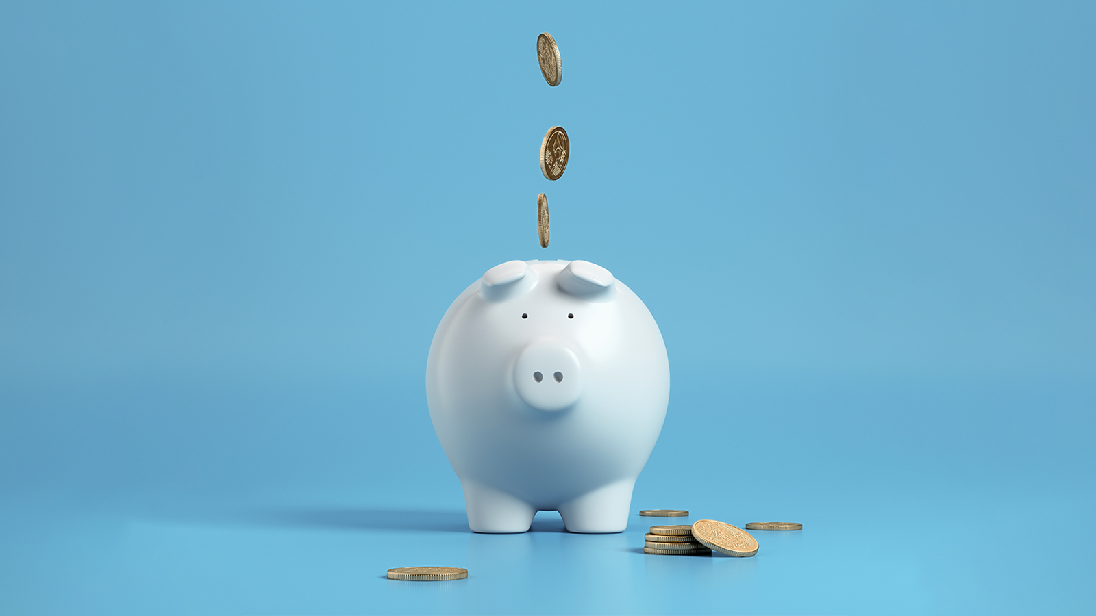 Coins falling into a piggy bank.