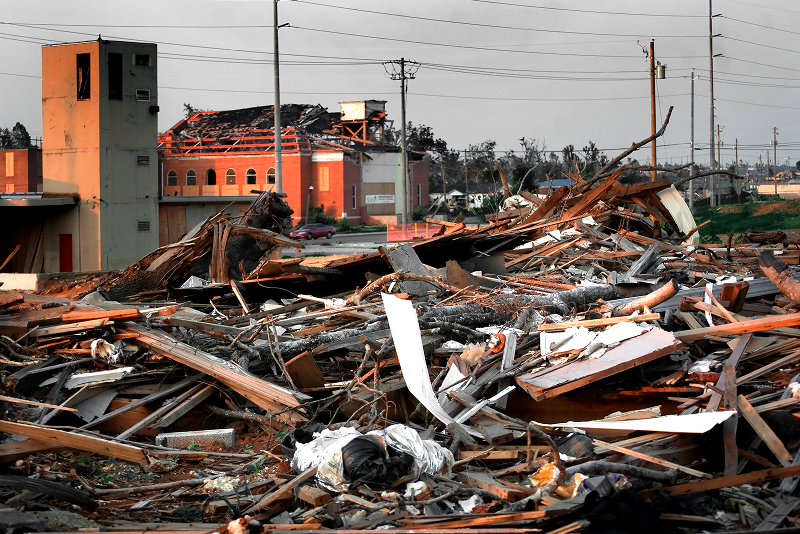 Severe tornado destruction in Tuscaloosa, Alabama, showing damaged houses and scattered debris.