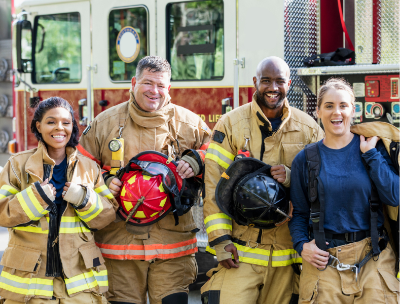 Four firefighters in front of a firetruck.